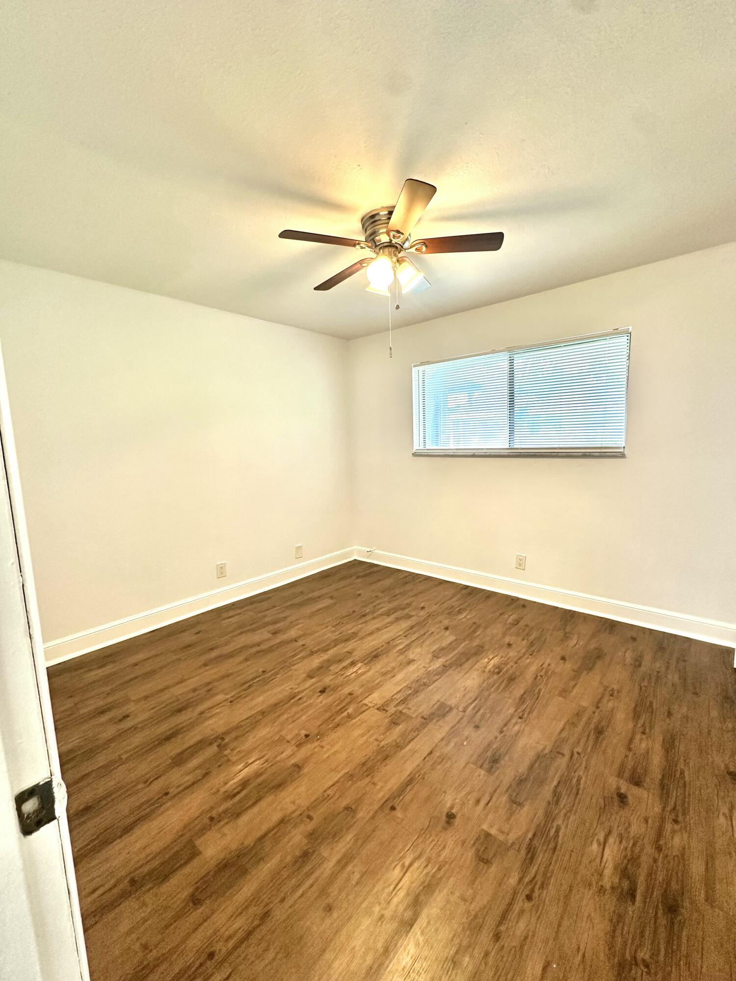 210 Tiffany Drive East, Unit 1 West Palm Beach, FL 33407 - Photo 5 of 10 wooden floor in an empty room
