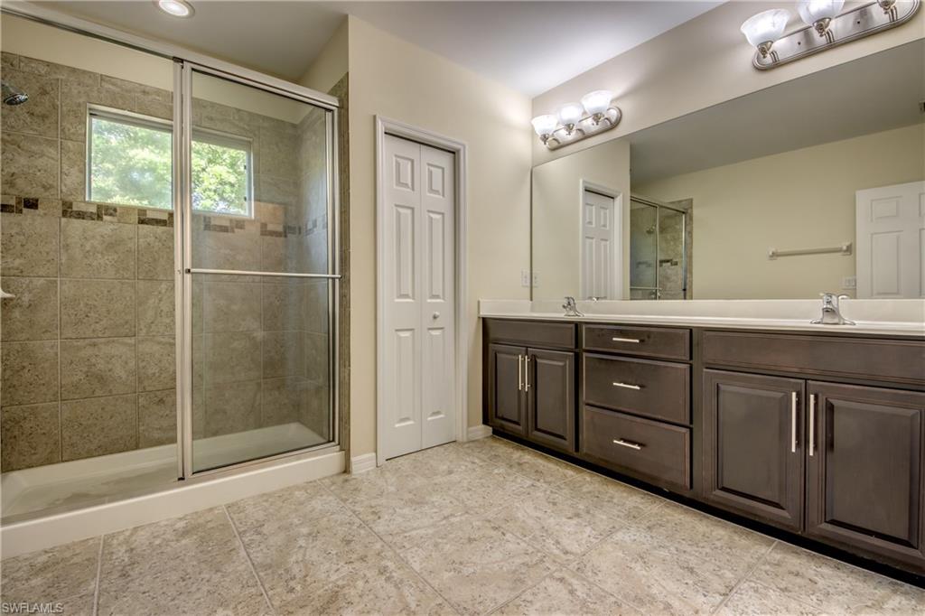 19530 Bowring Park Road, Unit 106 Fort Myers, FL 33967 - Photo 20 of 39 a spacious bathroom with a granite countertop sink mirror and shower