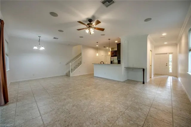 a view of a livingroom with a ceiling fan and kitchen space