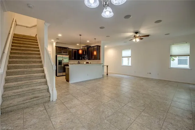 a view of a livingroom with furniture and chandelier fan