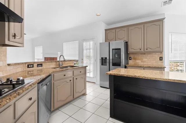 a kitchen with granite countertop a sink stove and cabinets