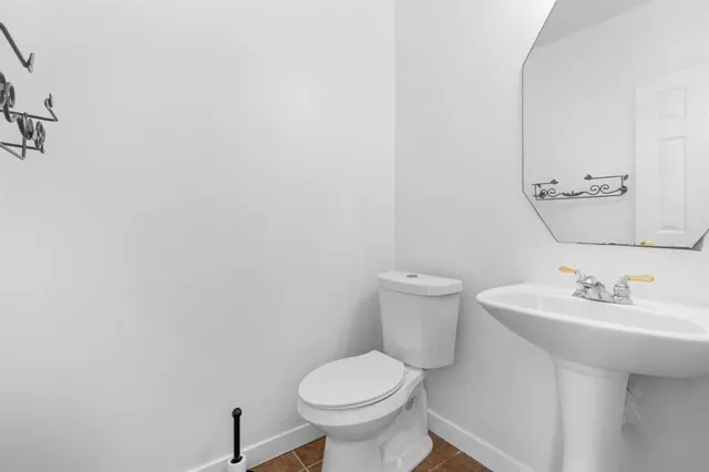 a bathroom with a sink toilet and a mirror