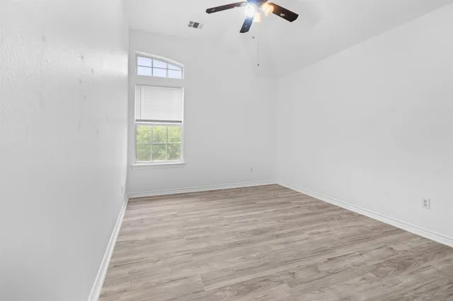 an empty room with a window and a fan
