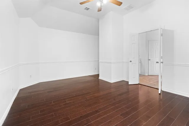 a view of empty room with wooden floor