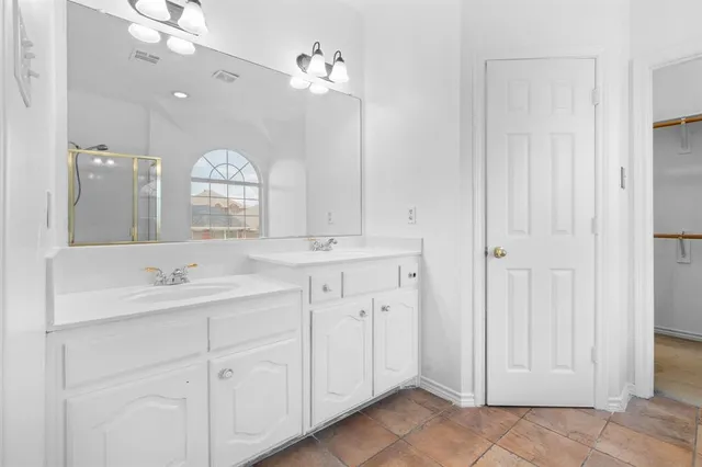 a bathroom with a double vanity sink and a mirror