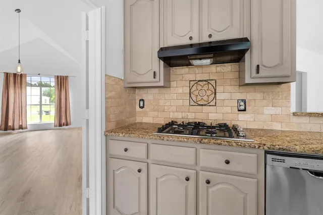 a kitchen with granite countertop white cabinets and white appliances