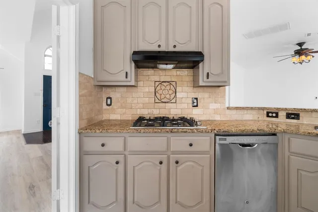 a kitchen with white cabinets and appliances