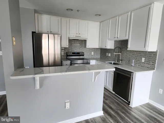 a kitchen with stainless steel appliances a stove a sink a microwave and cabinets