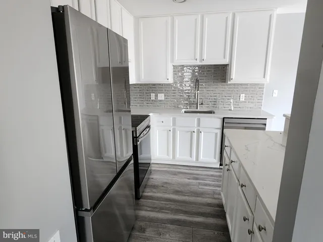a kitchen with stainless steel appliances a refrigerator and cabinets