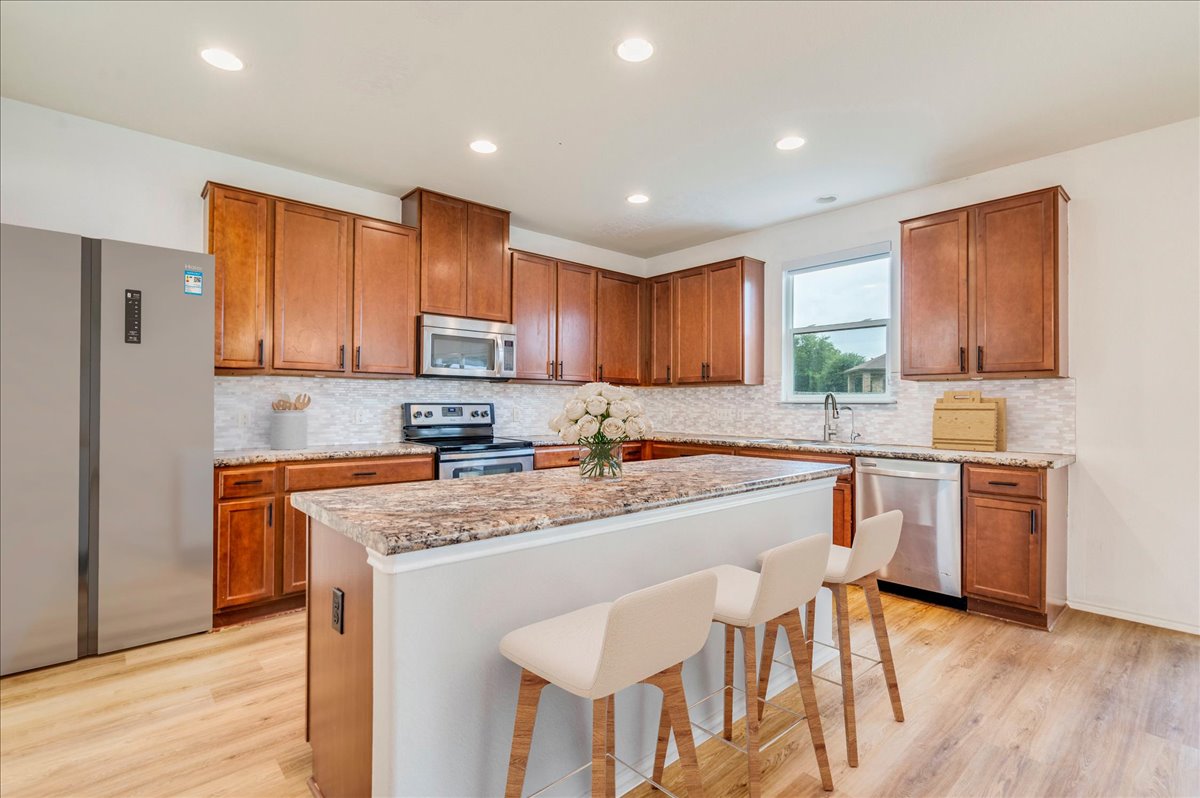401 Waterleaf Boulevard Kyle, TX 78640 - Photo 3 of 28 Kitchen with wood cabinets, stainless steel appliances, and new backsplash