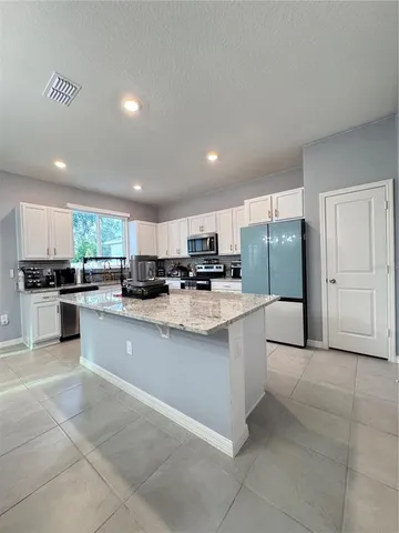 a kitchen with stainless steel appliances granite countertop a refrigerator and a stove