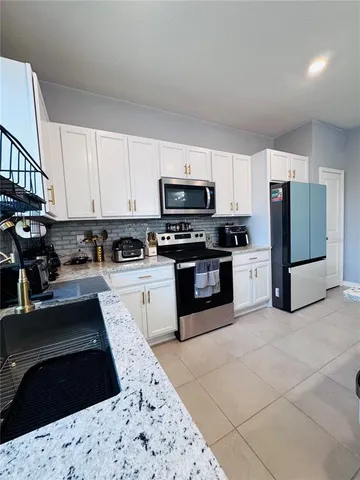 a kitchen with stainless steel appliances granite countertop a refrigerator a stove top oven a sink and dishwasher