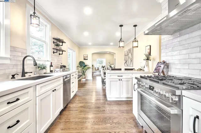 a large white kitchen with stainless steel appliances