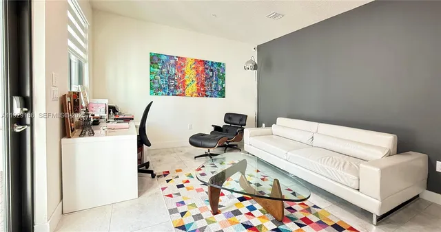 a living room with furniture and a floor to ceiling window