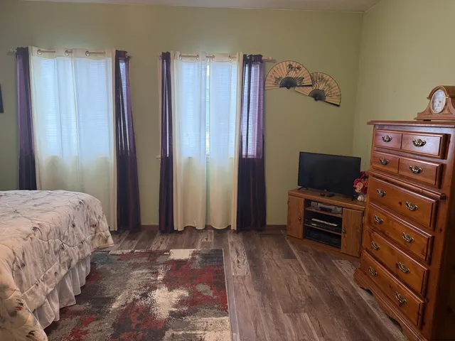 a bedroom with a bed and wooden floor