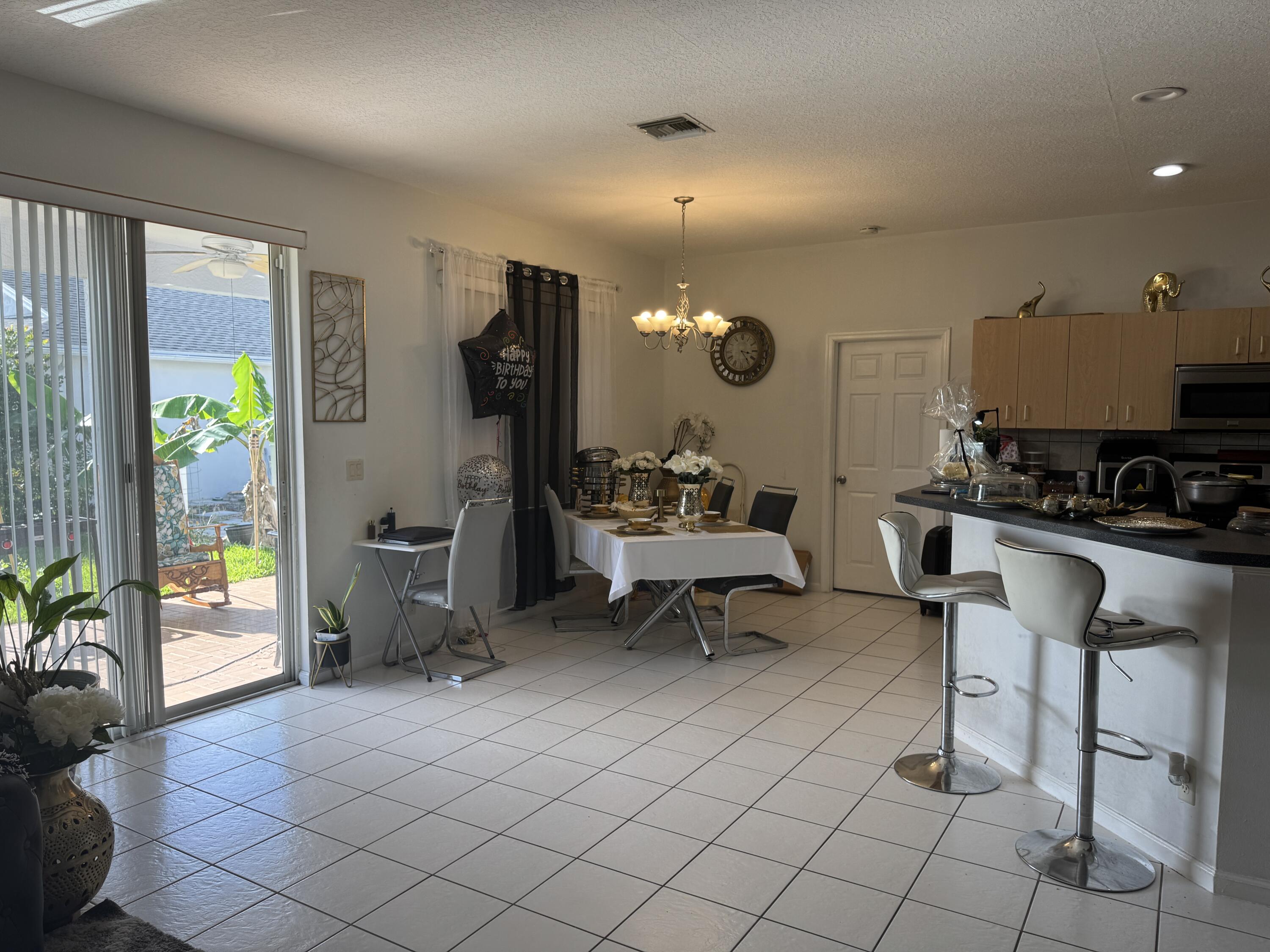 1011 Salmon Isle Greenacres, FL 33413 - Photo 13 of 28 a living room with furniture and a lamp