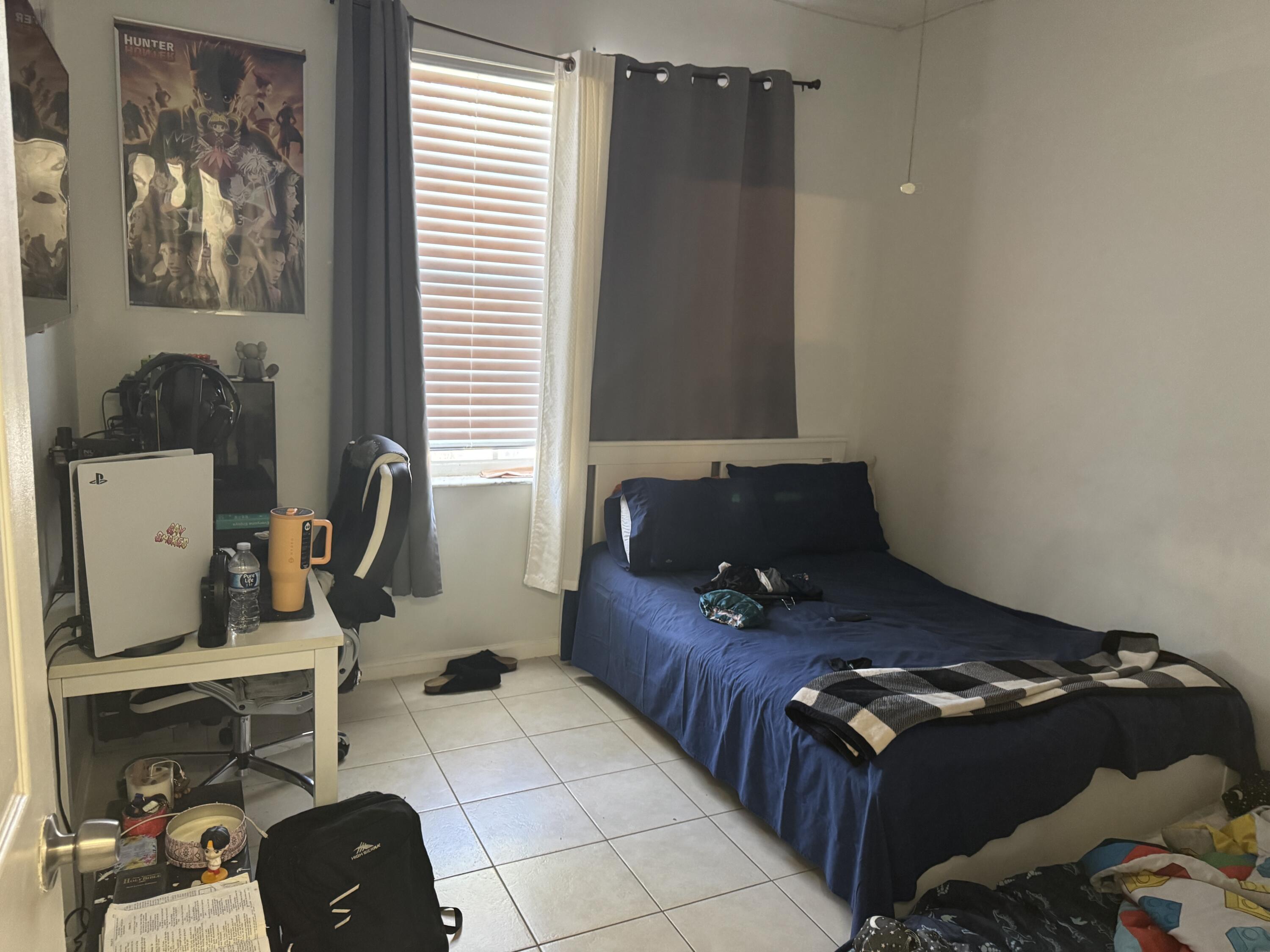 1011 Salmon Isle Greenacres, FL 33413 - Photo 17 of 28 a bed sitting in a bedroom next to a window