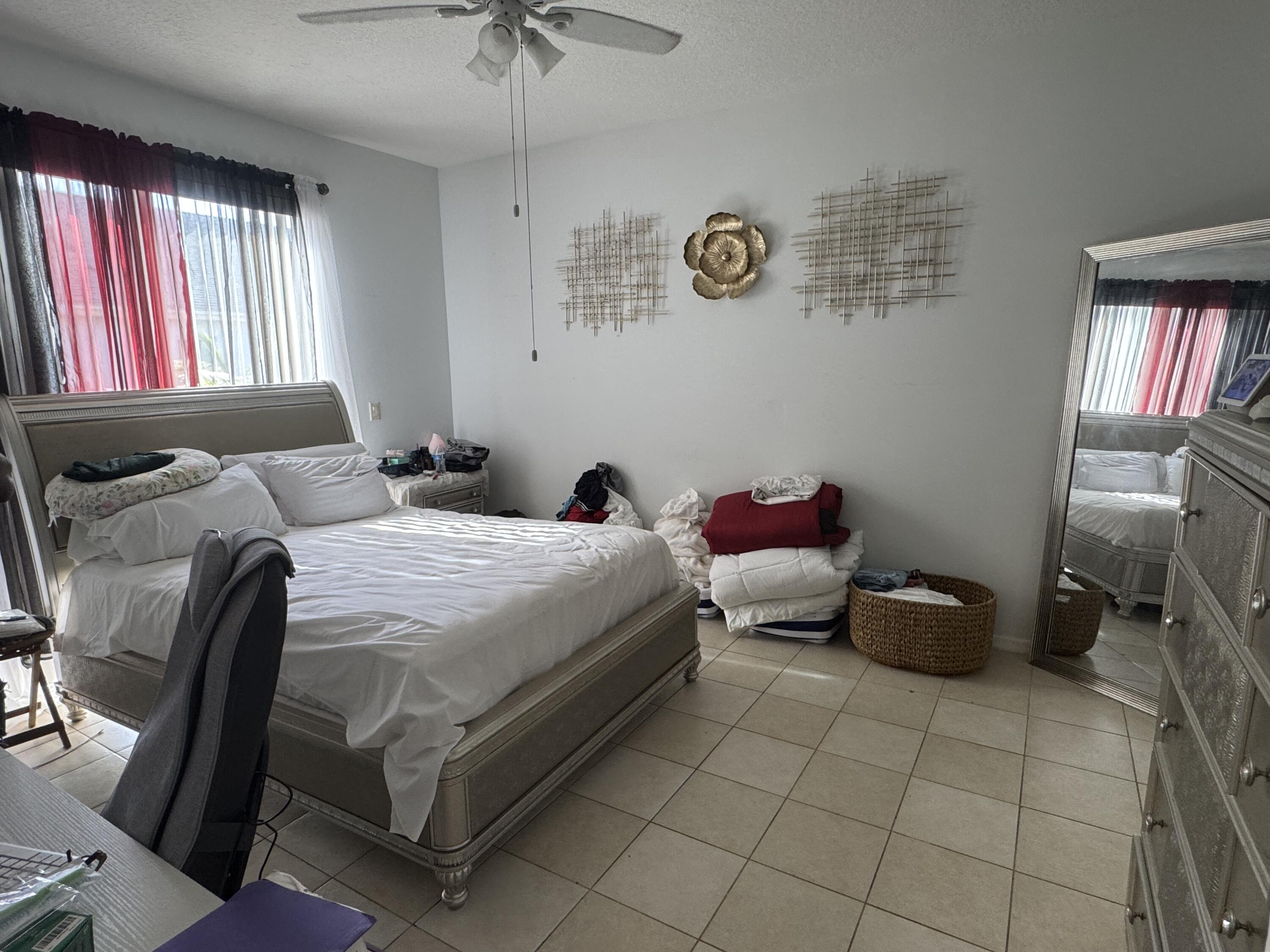 1011 Salmon Isle Greenacres, FL 33413 - Photo 23 of 28 a bedroom with a bed and a chandelier