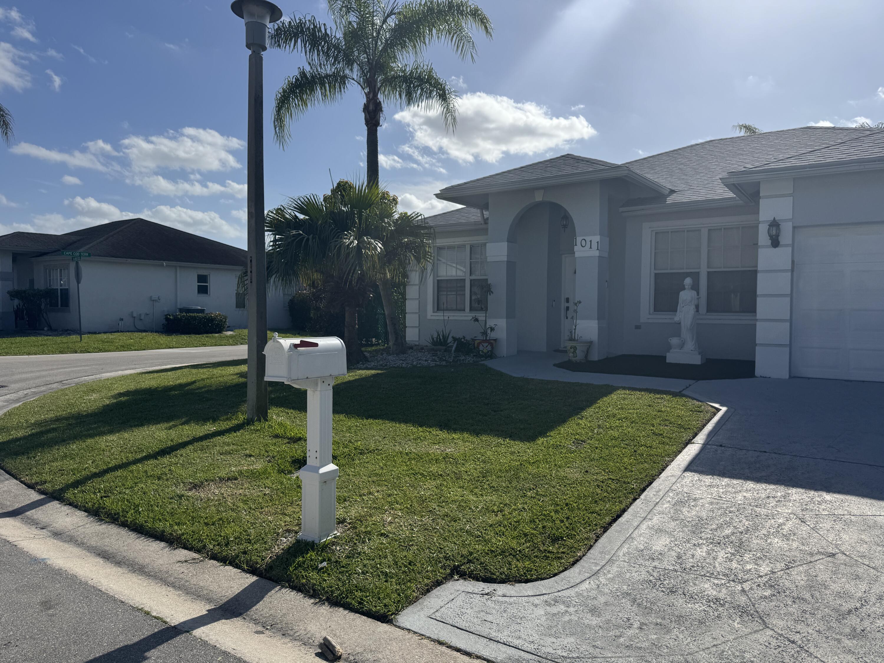 1011 Salmon Isle Greenacres, FL 33413 - Photo 3 of 28 a front view of a house with garden