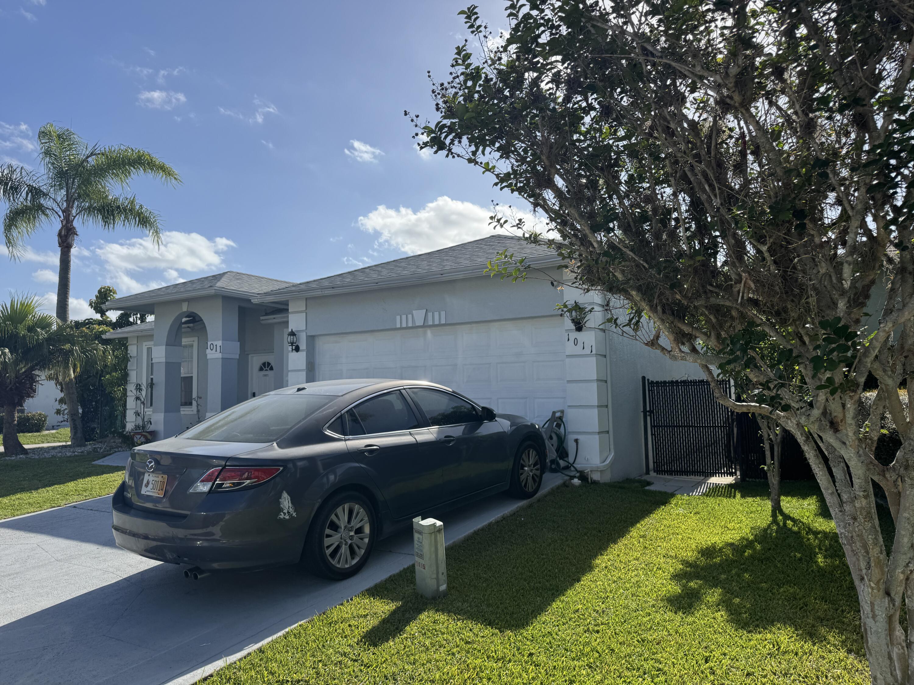 1011 Salmon Isle Greenacres, FL 33413 - Photo 5 of 28 a car parked in front of white house