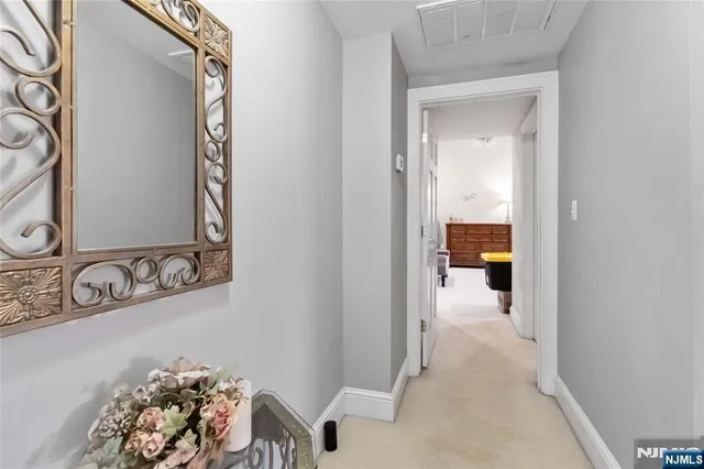 a view of a room that has a bed and a mirror in it