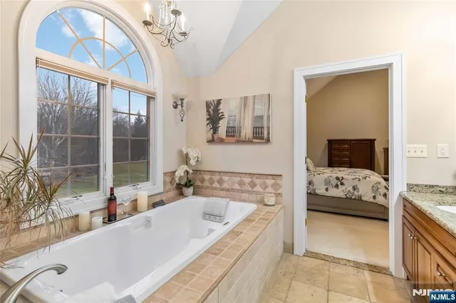 a bathroom with a tub a large window and a balcony view