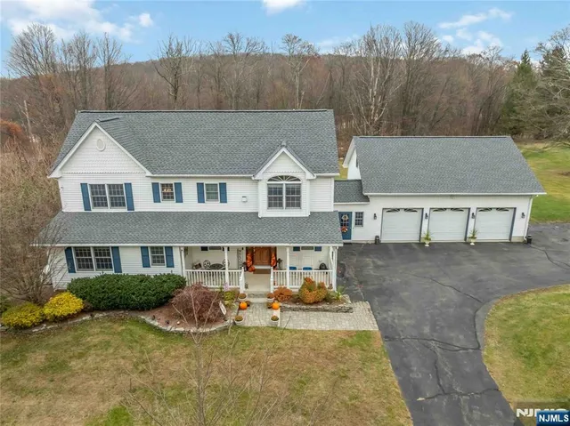 a view of a white house with a yard and sitting area