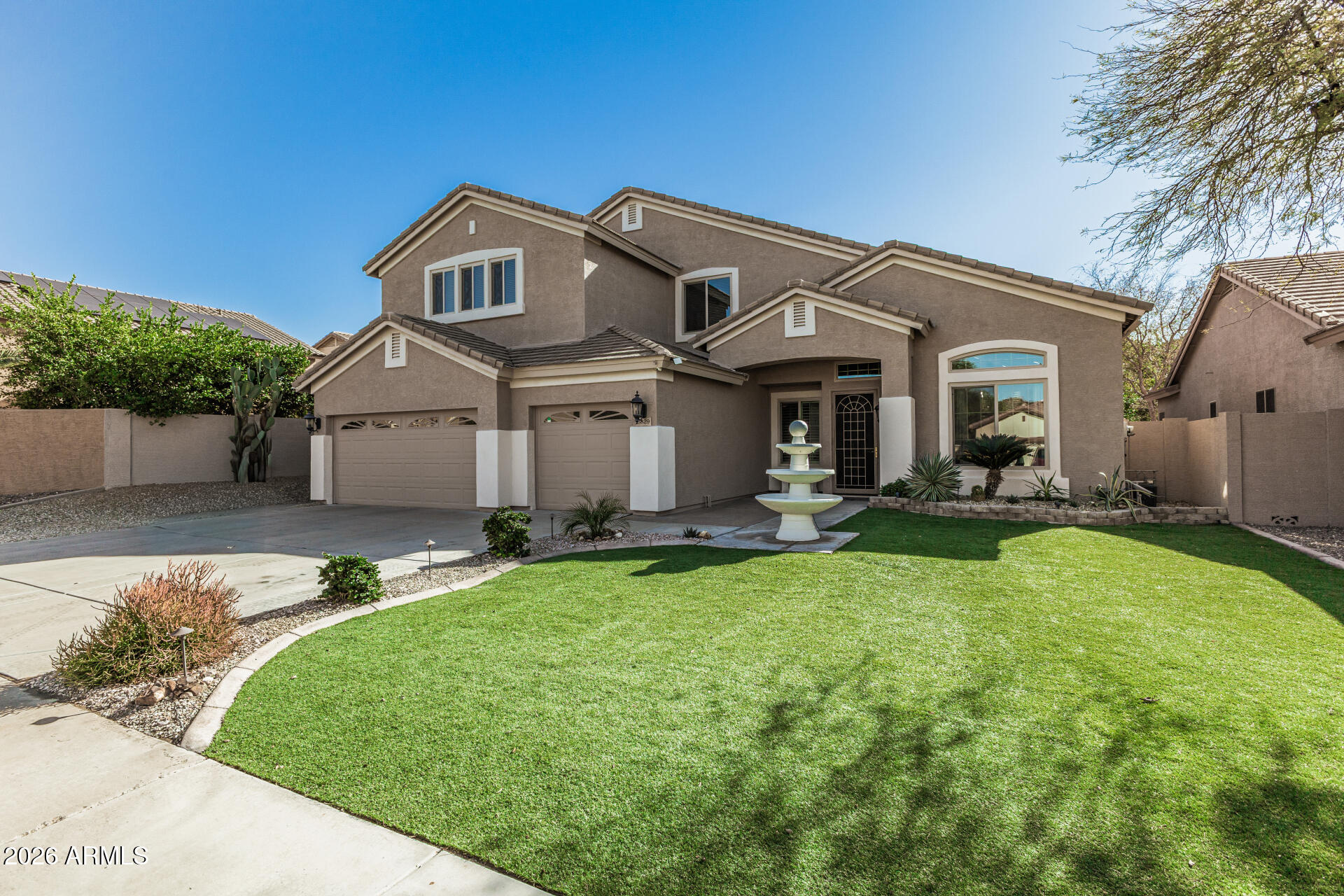 a front view of a house with a garden and plants