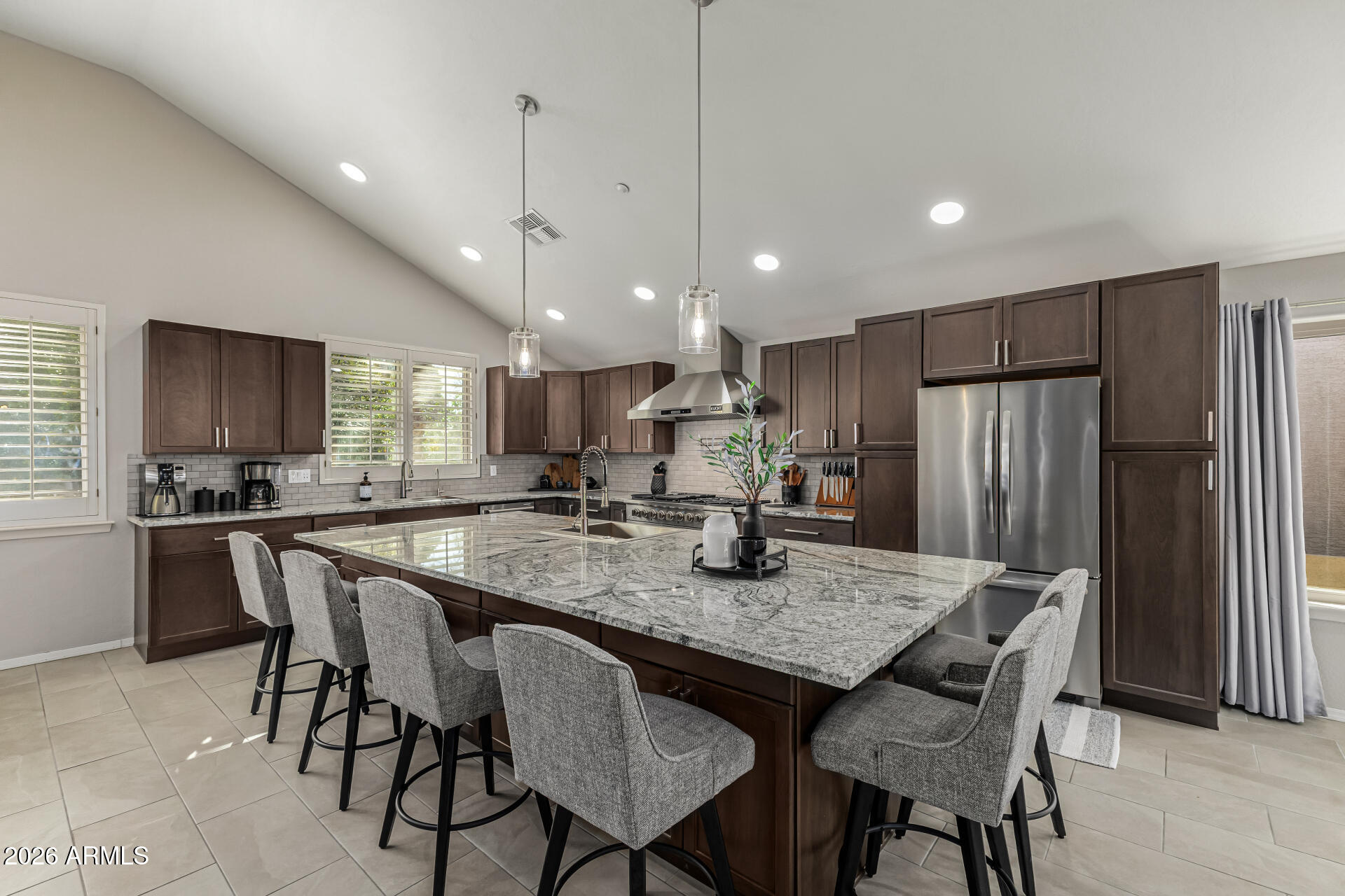 6829 West Briles Road Peoria, AZ 85383 - Photo 13 of 61 a kitchen with stainless steel appliances granite countertop a dining table chairs refrigerator and microwave