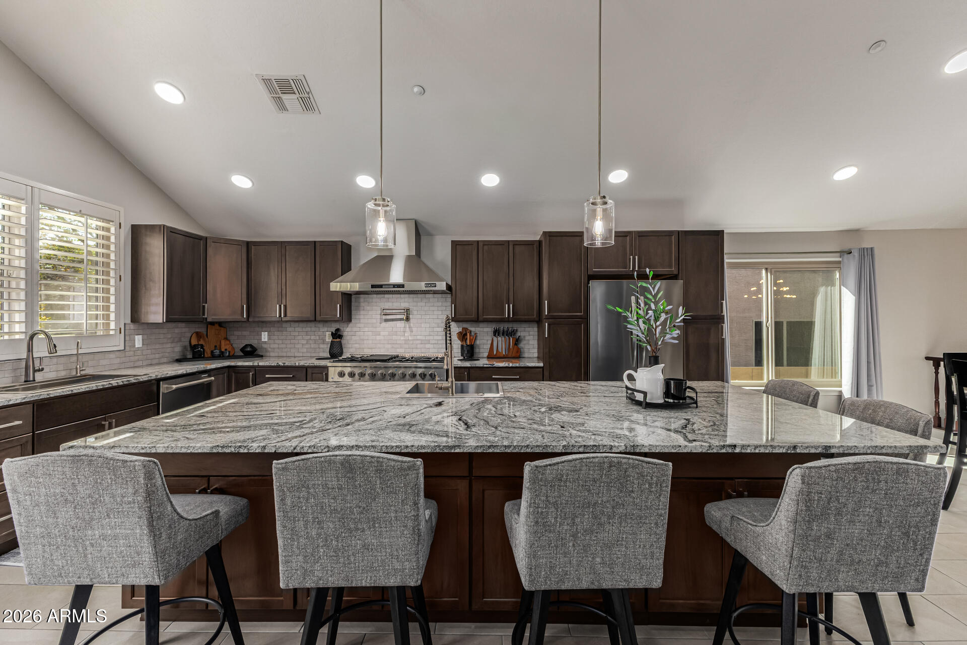 6829 West Briles Road Peoria, AZ 85383 - Photo 14 of 61 a kitchen with granite countertop kitchen island a dining table and chairs