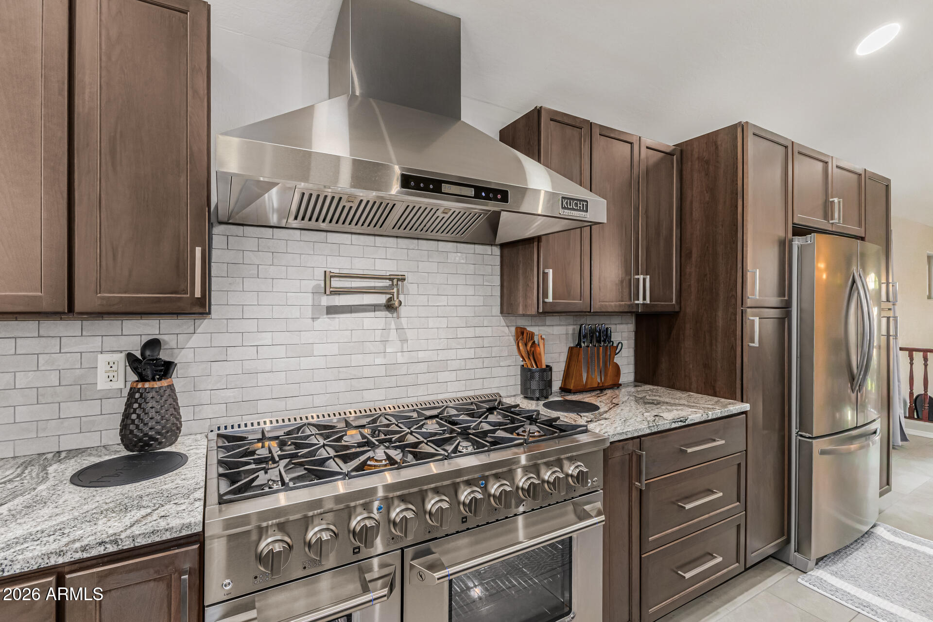 6829 West Briles Road Peoria, AZ 85383 - Photo 18 of 61 a kitchen with granite countertop a stove and a refrigerator