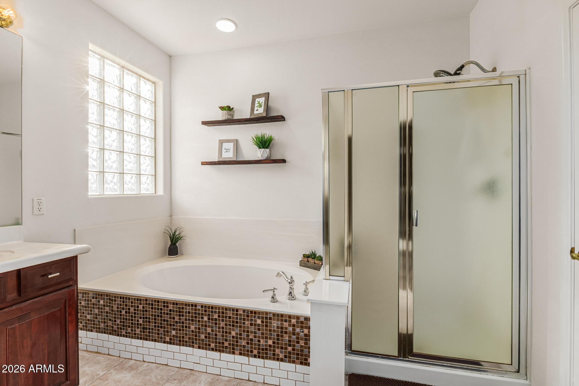6829 West Briles Road Peoria, AZ 85383 - Photo 29 of 61 a bathroom with a bathtub a shower a vanity and a window