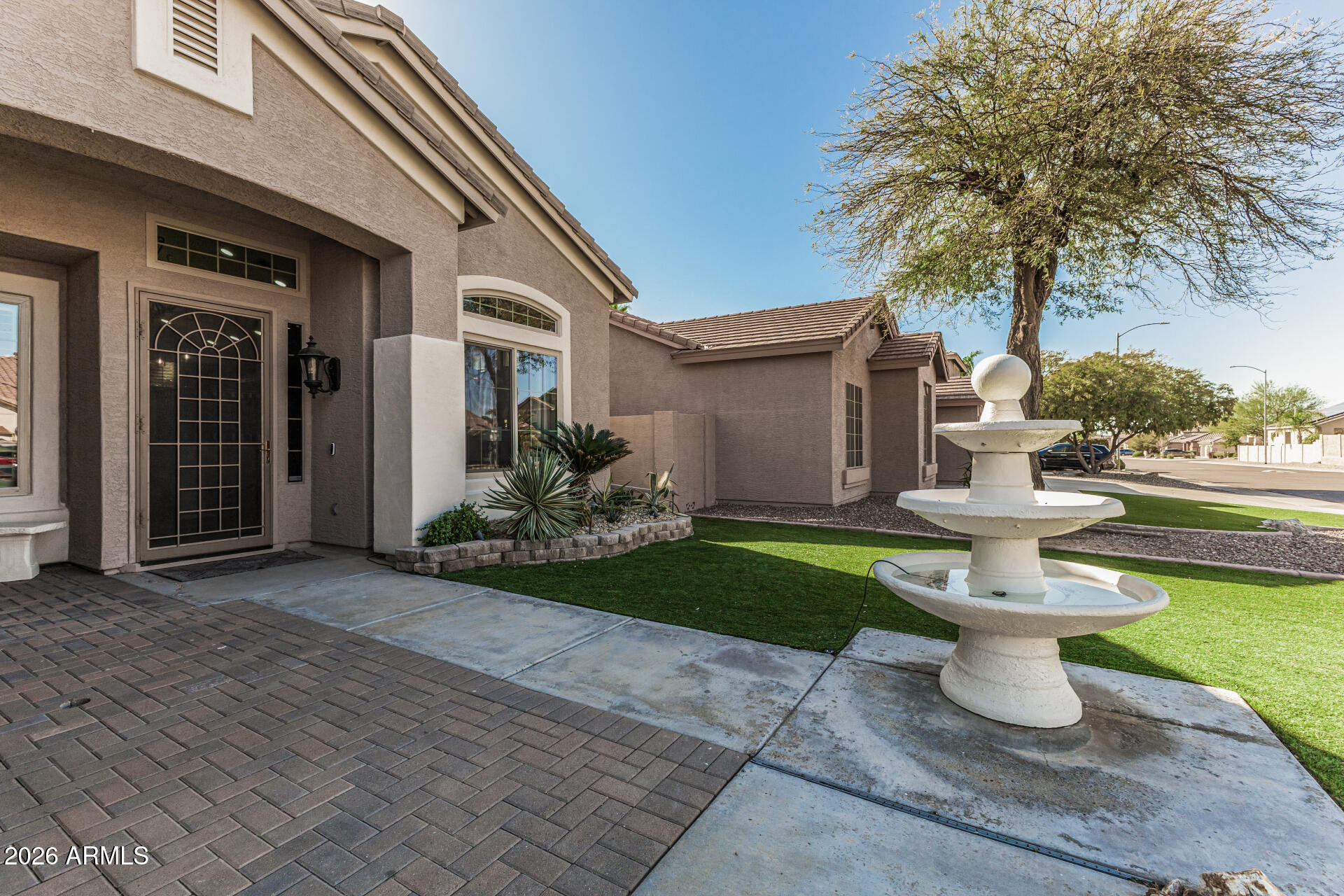 6829 West Briles Road Peoria, AZ 85383 - Photo 4 of 61 a front view of a house with a yard and fountain