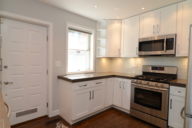 Undisclosed Address Chicago, IL 60614 - Photo 3 of 17 a kitchen with granite countertop a stove a sink and a microwave