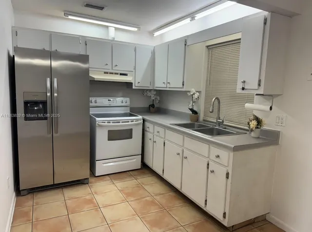 a kitchen with stainless steel appliances granite countertop a sink and a refrigerator