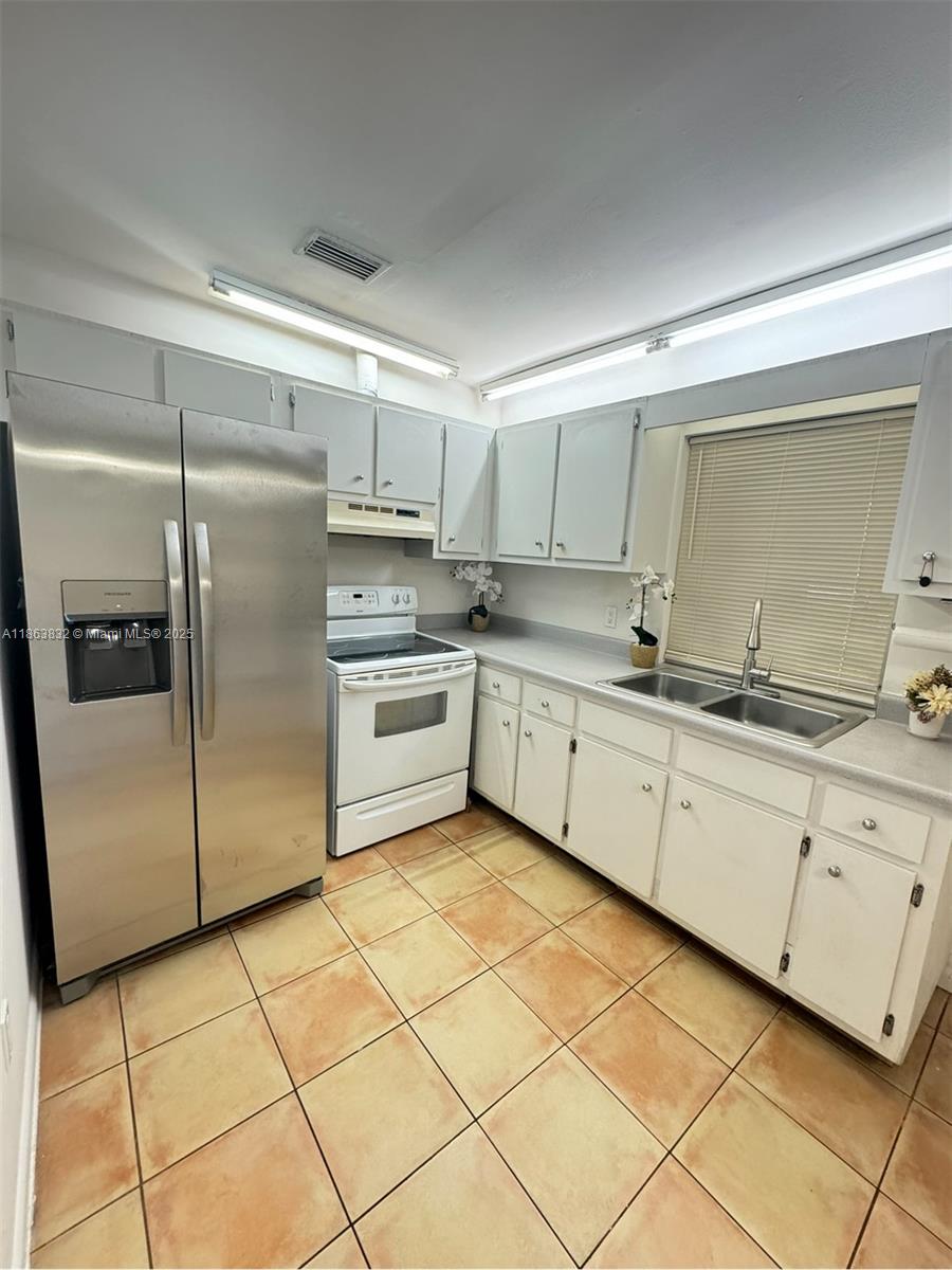 1327 Riverside Circle, Unit 1327 Wellington, FL 33414 - Photo 2 of 20 a kitchen with stainless steel appliances granite countertop a sink stove and refrigerator