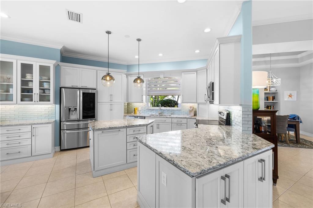 20196 Markward Crossing Estero, FL 33928 - Photo 2 of 42 a kitchen with stainless steel appliances granite countertop a sink a stove and a refrigerator