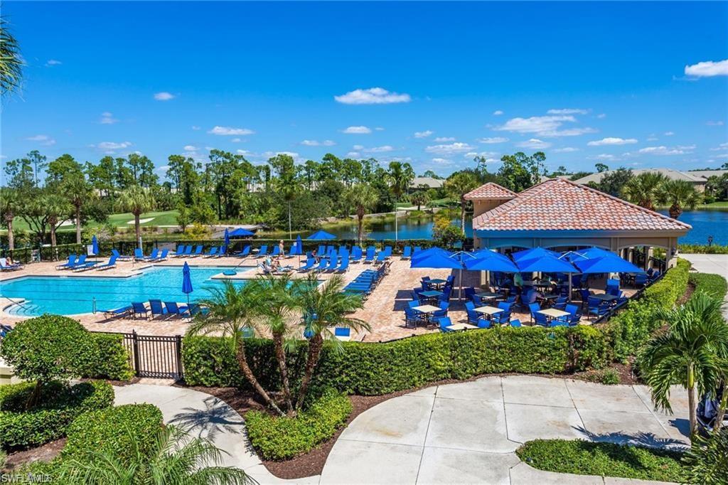 20196 Markward Crossing Estero, FL 33928 - Photo 37 of 42 a view of a swimming pool with lawn chairs under an umbrella