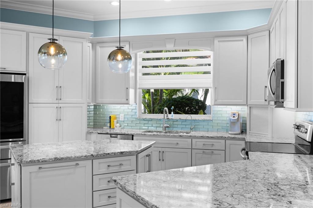 20196 Markward Crossing Estero, FL 33928 - Photo 4 of 42 a kitchen with kitchen island granite countertop a sink cabinets and stainless steel appliances