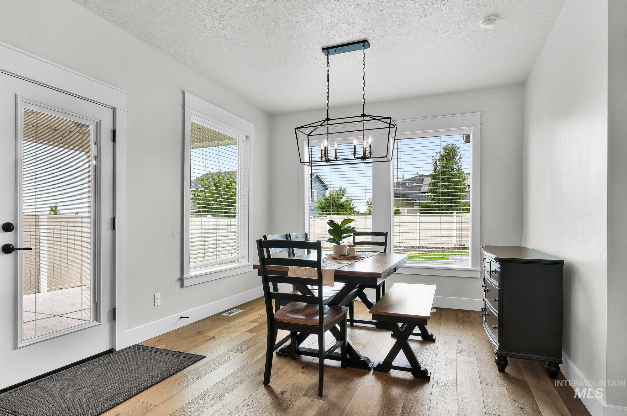 5676 East Zaffre Ridge Street Boise, ID 83716 - Photo 17 of 50 Bright dining area featuring wood-finish flooring and a contemporary linear chandelier