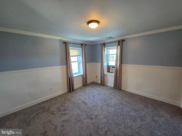 an empty room with windows and closet