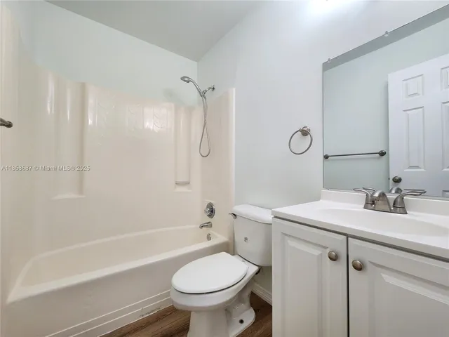 a bathroom with a sink toilet vanity and shower