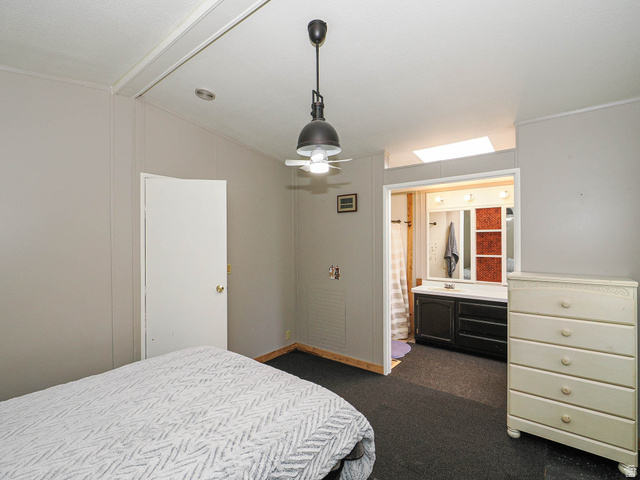 94 Spring Canyon Road Coalville, UT 84017 - Photo 41 of 50 Interior room featuring a ceiling fan with integrated lighting, a white door, and gray paneled walls