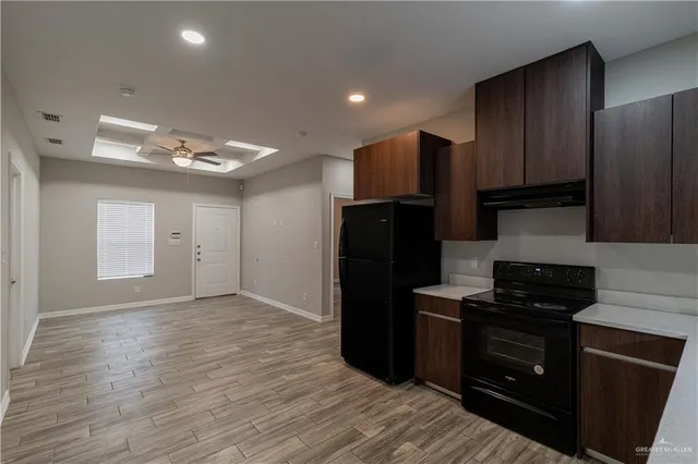 a kitchen with a refrigerator and a stove top oven