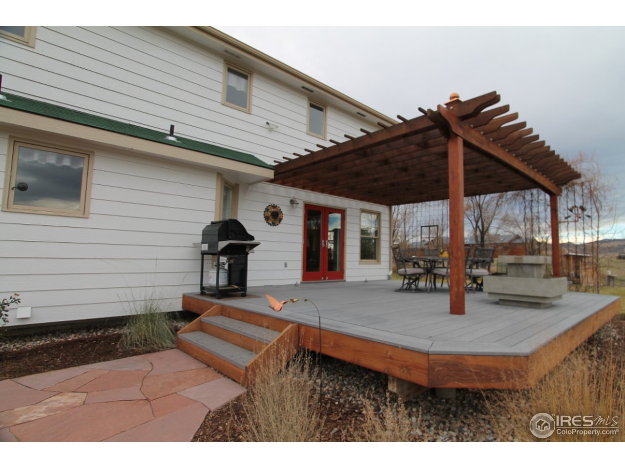411 High Court Fort Collins, CO 80521 - Photo 22 of 25 a view of a patio with a table and chairs under an umbrella