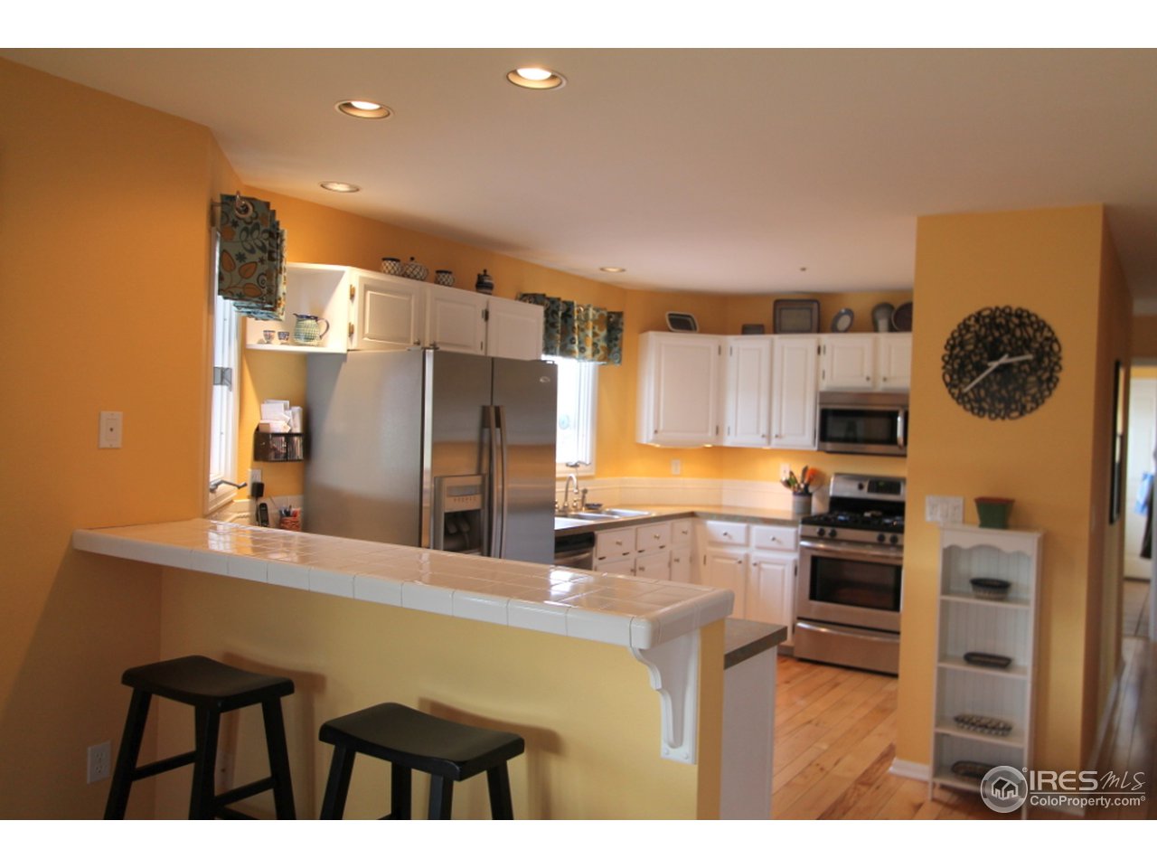 411 High Court Fort Collins, CO 80521 - Photo 7 of 25 a kitchen with stainless steel appliances kitchen island granite countertop a sink refrigerator and cabinets