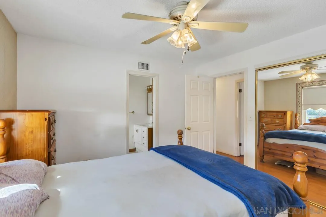 9326 Oakbourne Road Santee, CA 92071 - Photo 19 of 41 a bedroom with a bed and a chandelier
