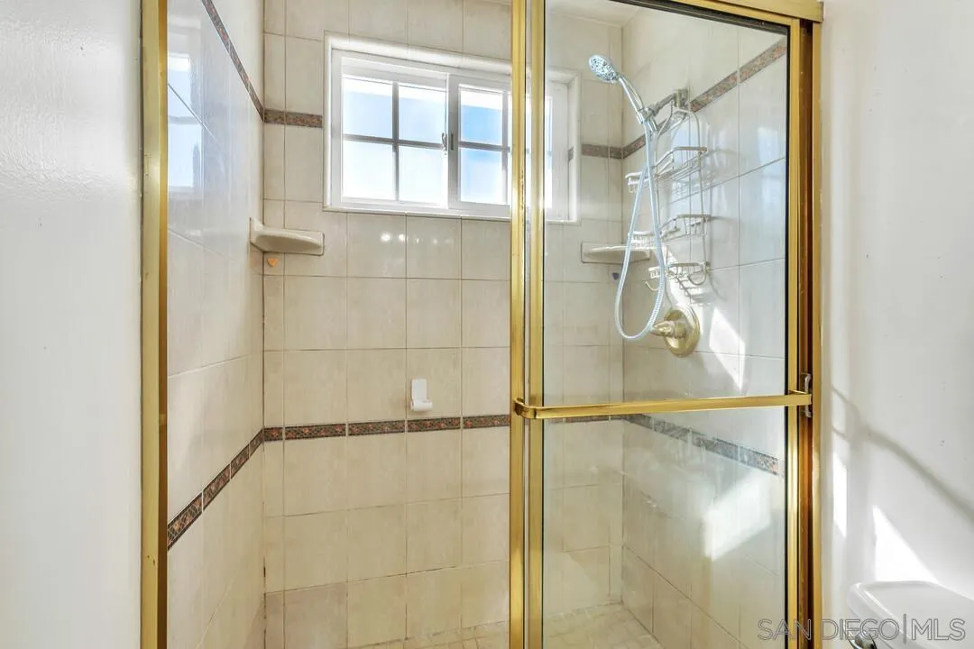 9326 Oakbourne Road Santee, CA 92071 - Photo 21 of 41 a bathroom with a glass shower door