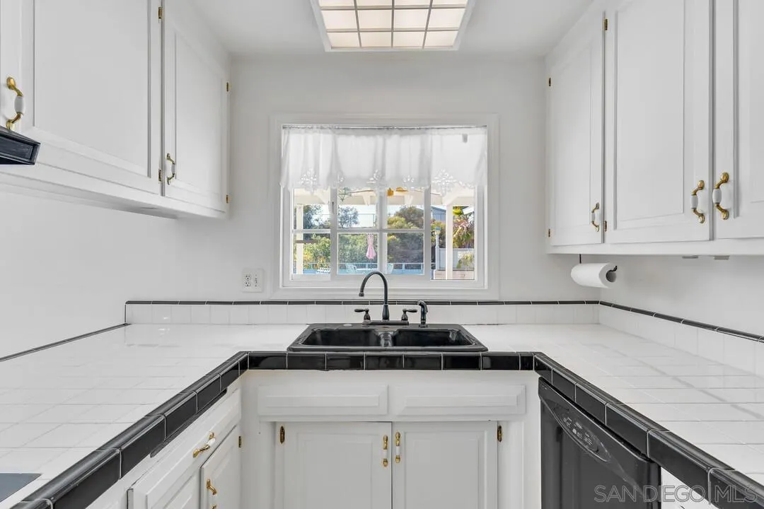 9326 Oakbourne Road Santee, CA 92071 - Photo 7 of 41 a kitchen with granite countertop white cabinets and a sink