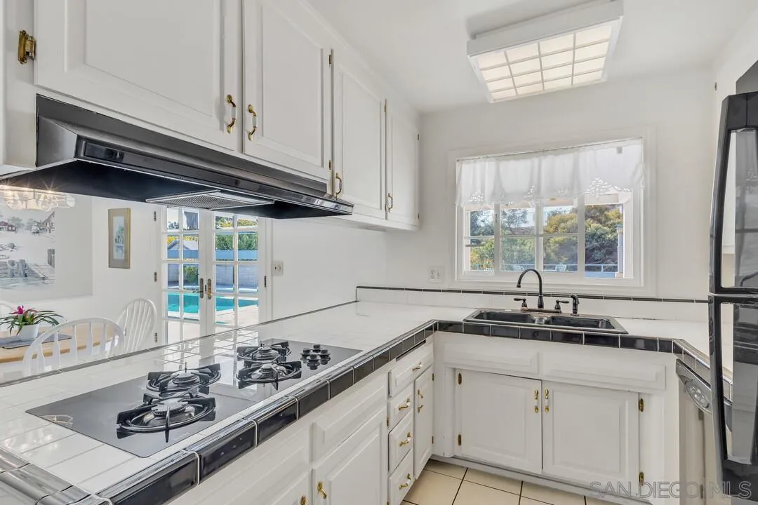 9326 Oakbourne Road Santee, CA 92071 - Photo 8 of 41 a kitchen with stainless steel appliances a sink a stove and a window